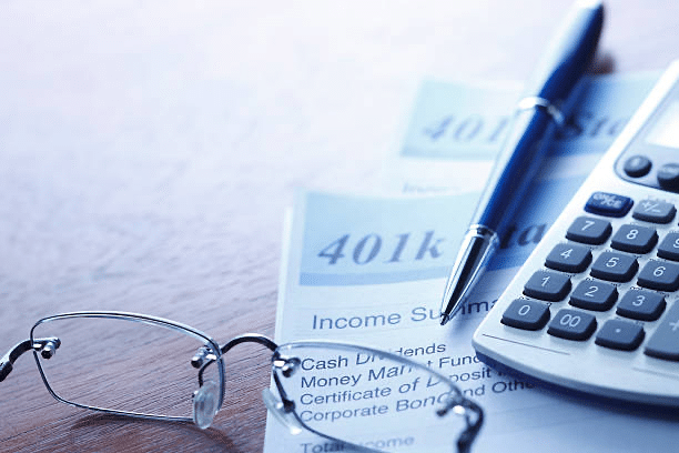 close up of eye glasses, pen and calculator on a table